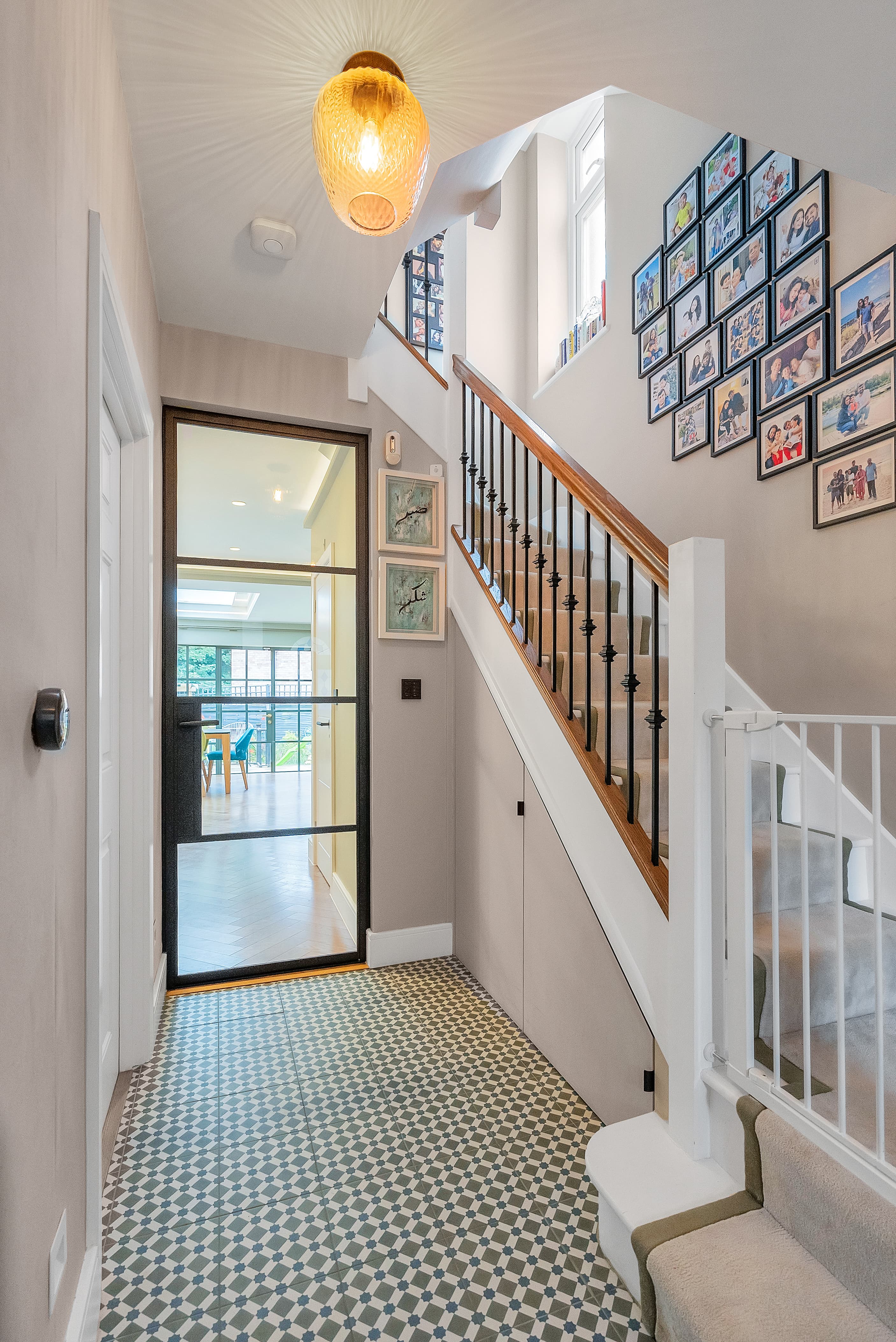 Entrance hall with geometric tiles and traditional staircase