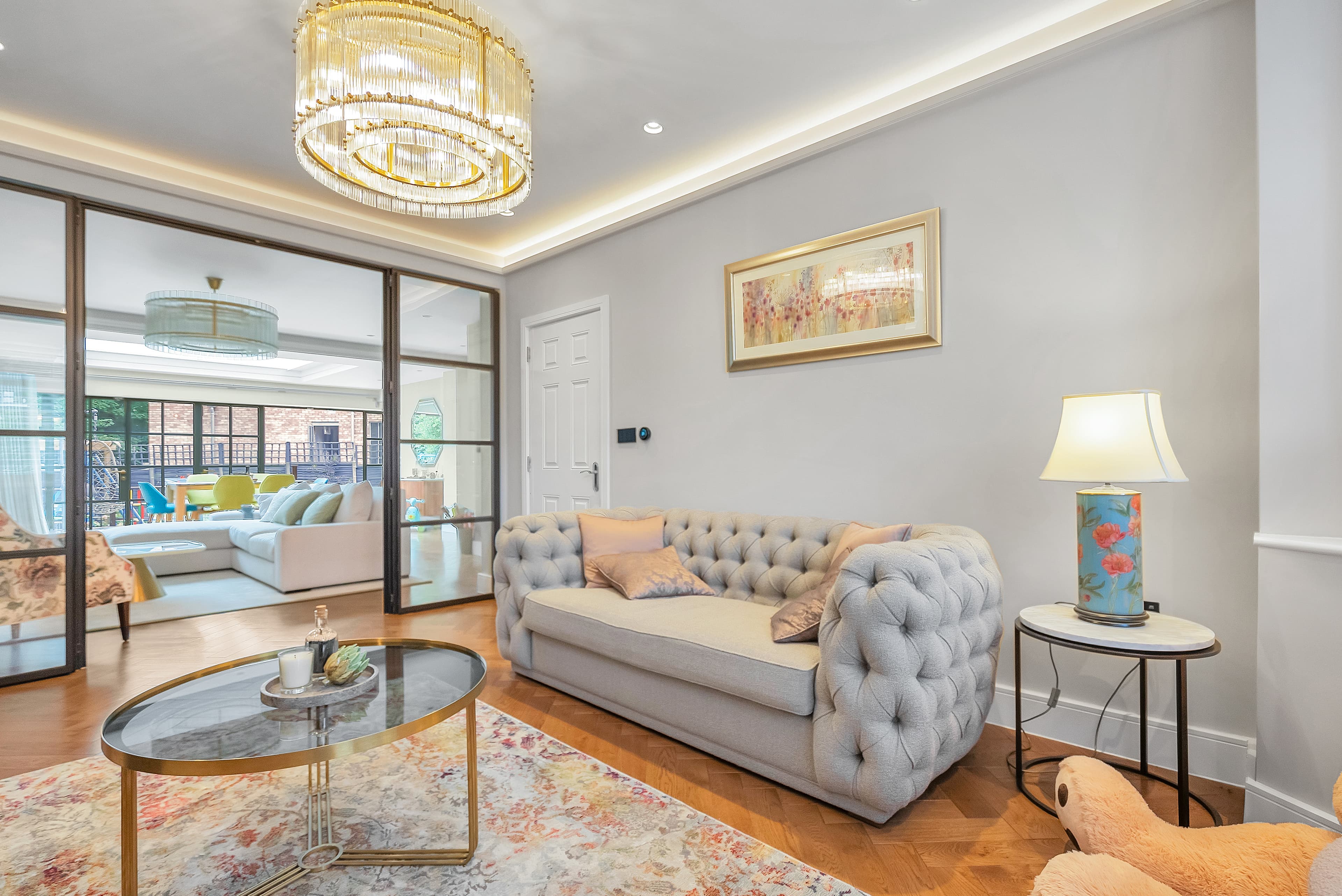 Living room with gold chandelier and sliding glass doors