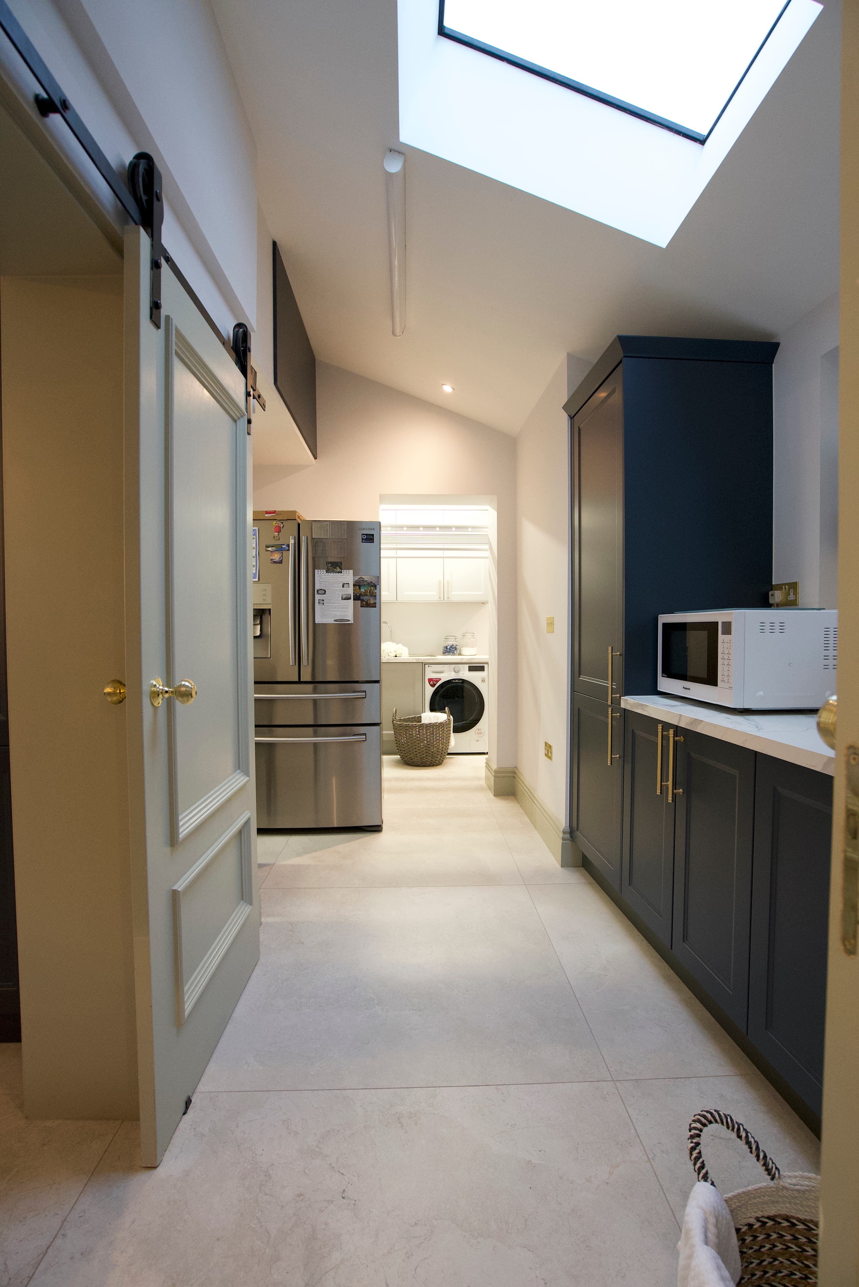 Utility with barn door and navy cabinetry