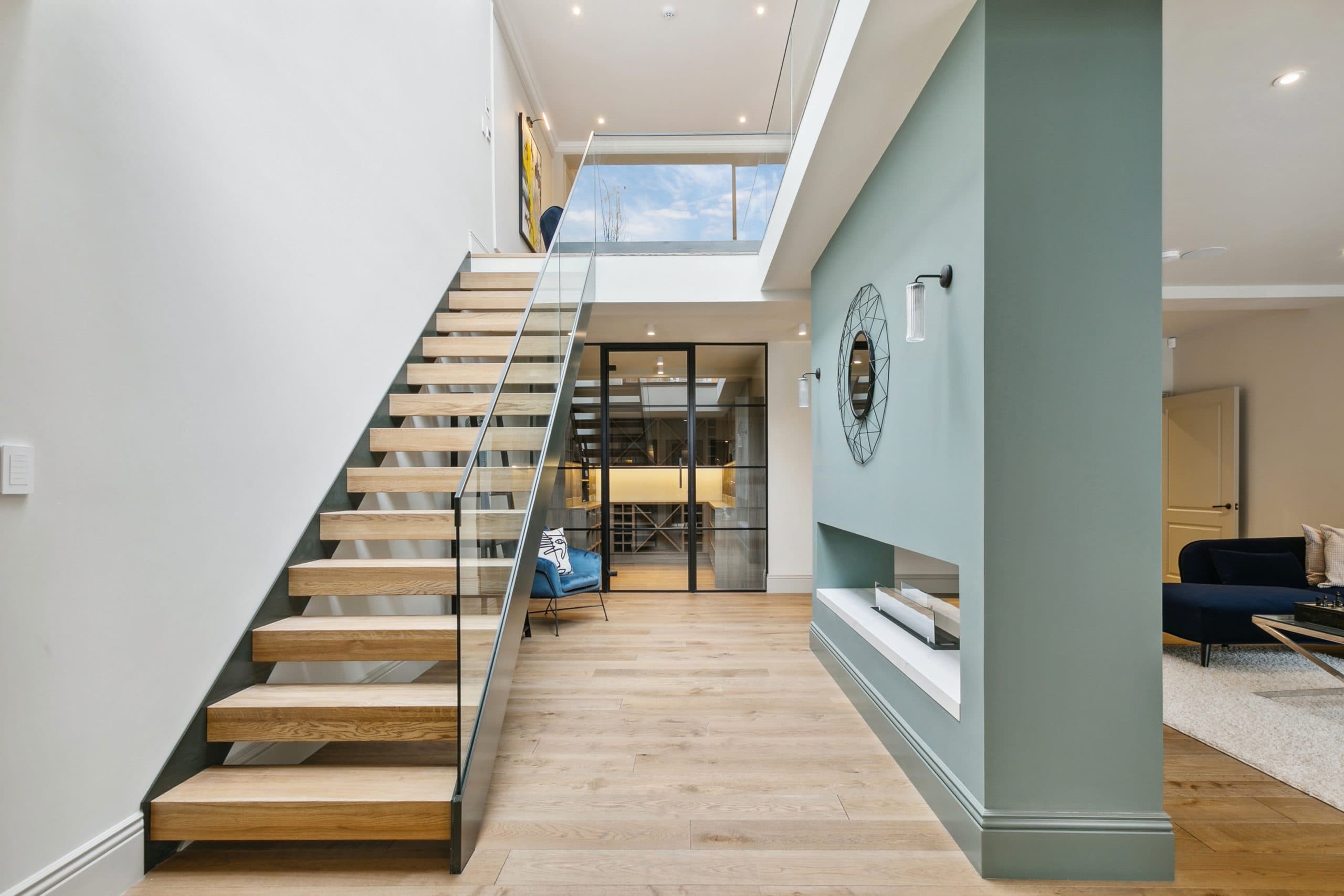 Sculptural oak and glass staircase connecting levels