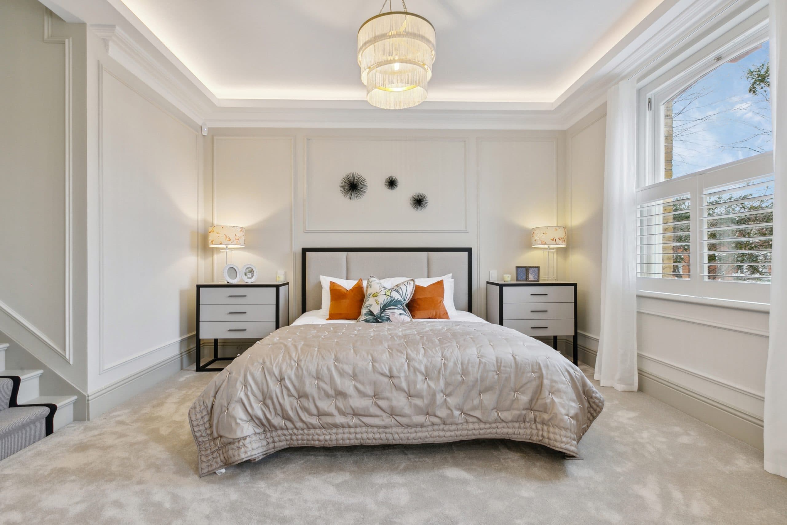 Guest bedroom with upholstered headboard and statement lamps