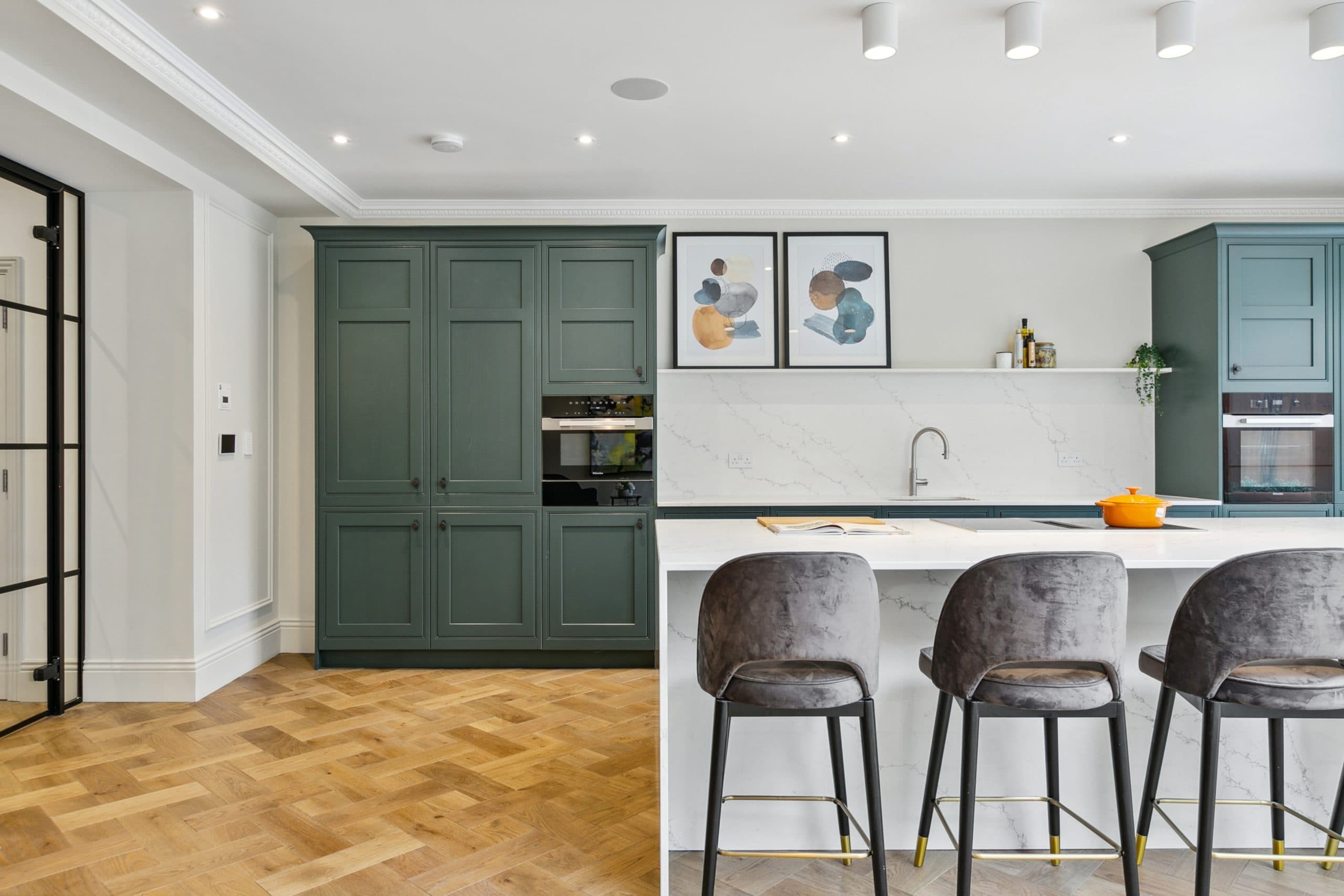 Kitchen detail with brass hardware and velvet bar stools