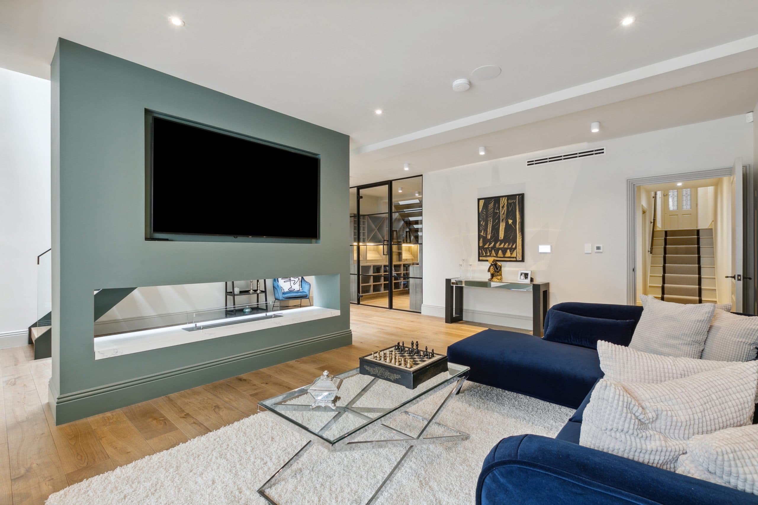 Lower living area with media wall and linear fireplace