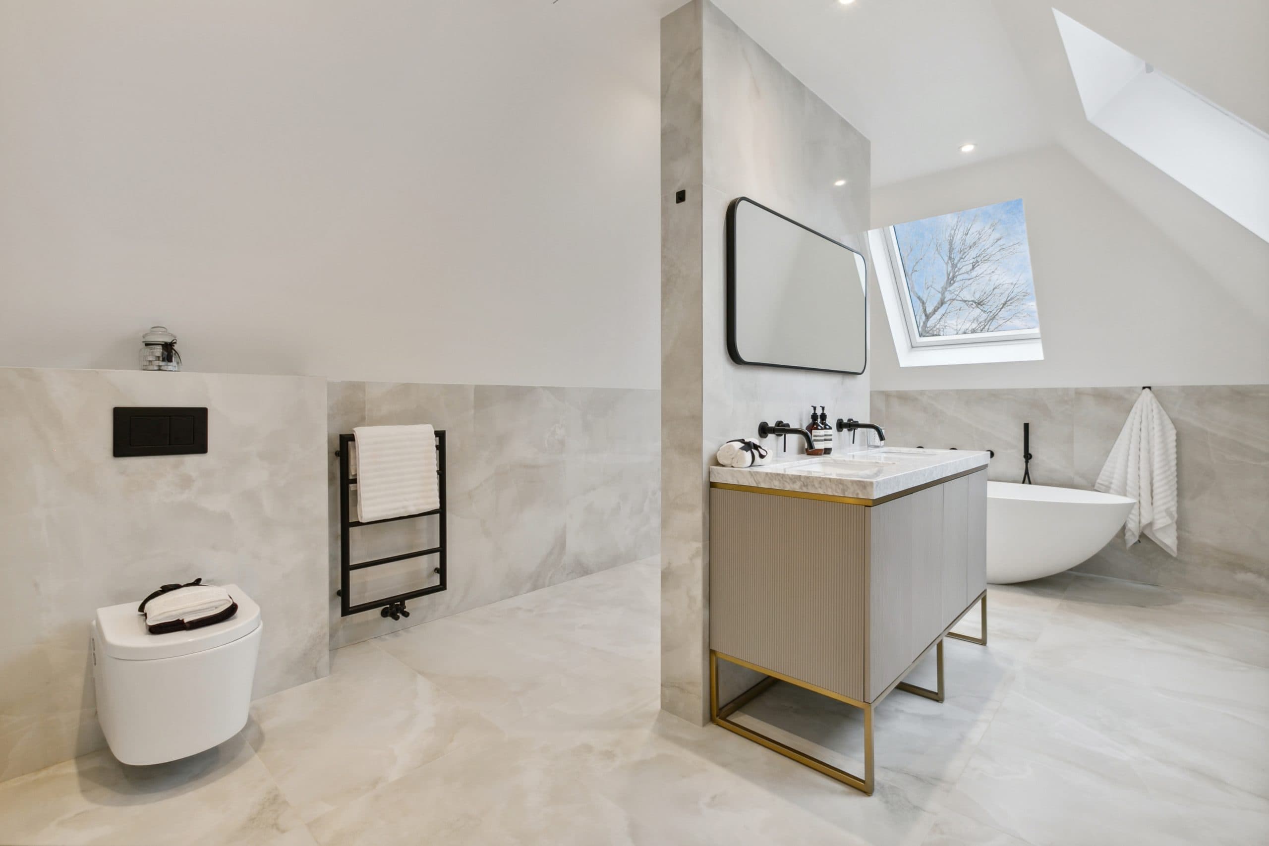 Loft en-suite with marble tiles and freestanding bath