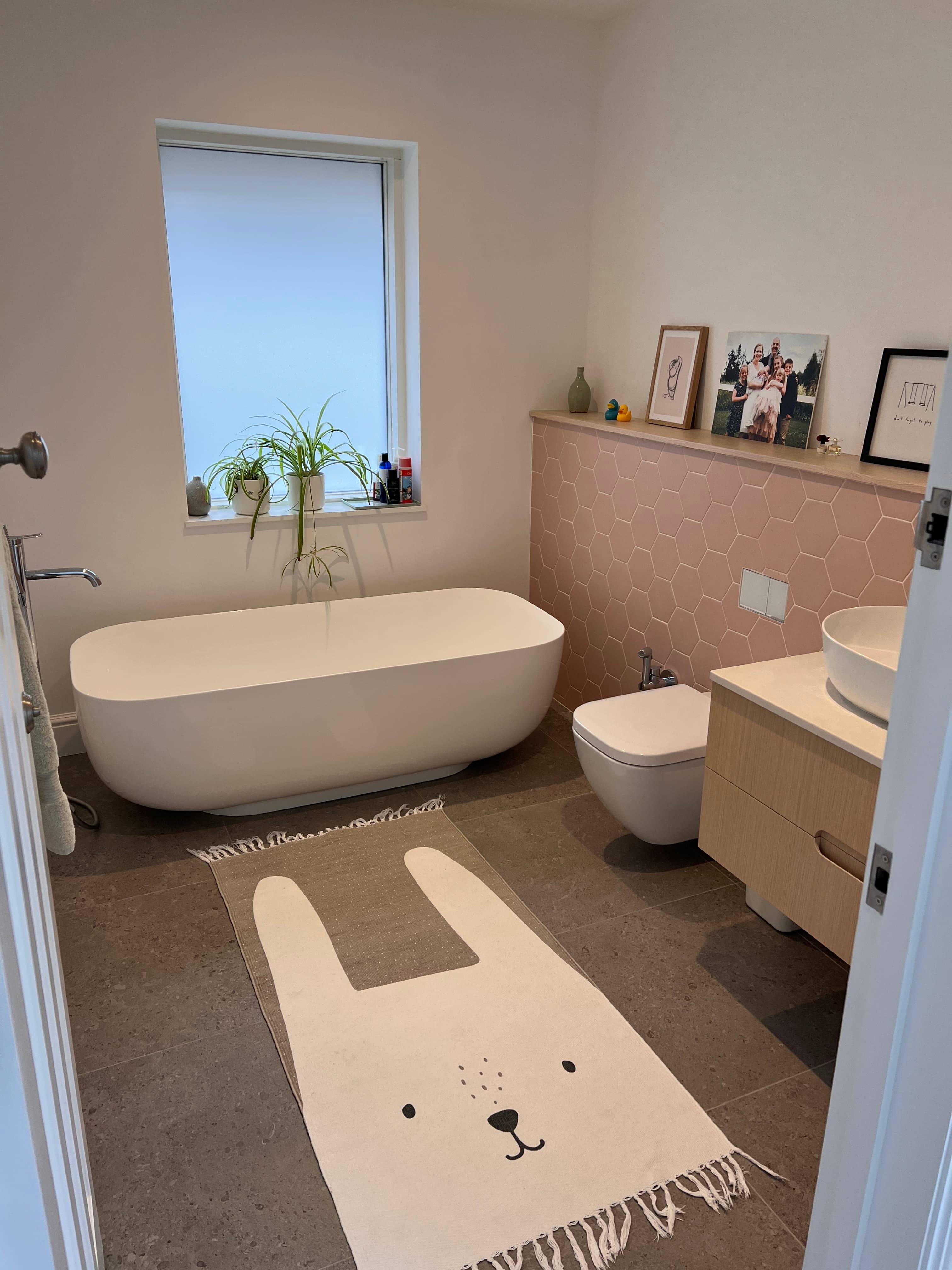 Family bathroom with freestanding bath and pink hexagonal tiles